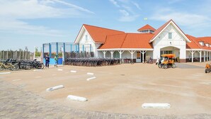 A building with a red-tiled roof and a covered area with bicycles.