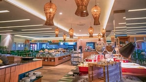 Eine Hotelhalle mit einem Buffetbereich, Holzmöbeln und hängenden Pendelleuchten.