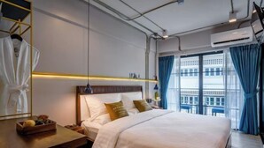 Quarto de hotel com cama, mesa de cabeceira e vista para a cidade.