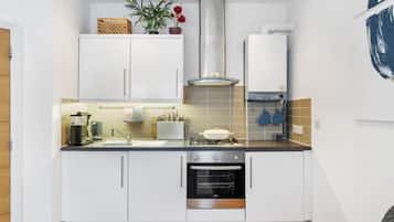 Microondas, horno, utensilios de cocina y mesa de comedor