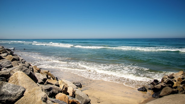 A rocky beach with waves crashing onto the shore.