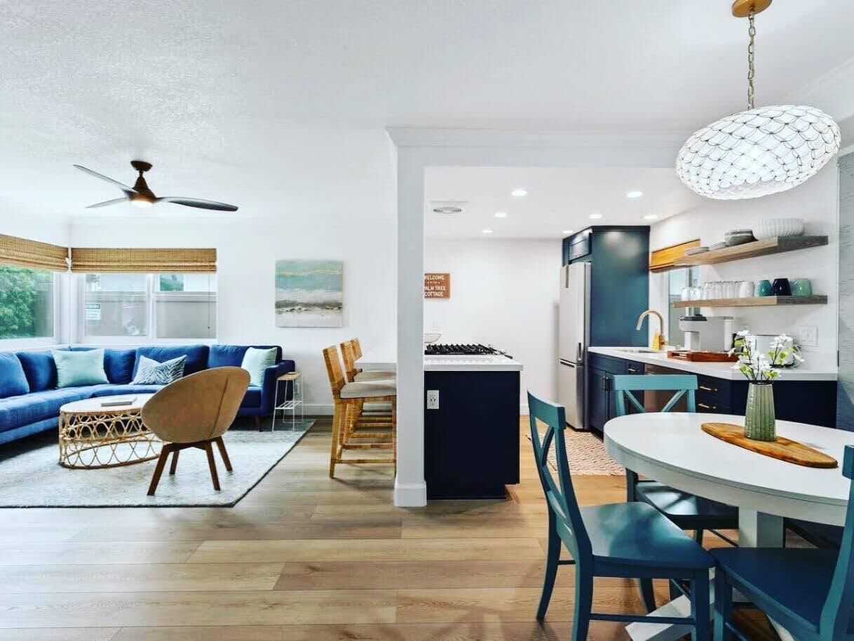 A modern living room with a sofa, chairs, and a dining area with a table and chairs.