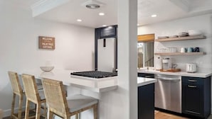 A modern kitchen with a built-in island, dark cabinetry, and a white countertop.
