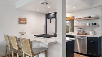 A modern kitchen with a built-in island, dark cabinetry, and a white countertop.
