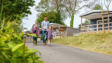 A family walking on a paved path with a modern building in the background.