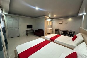 A hotel room with two beds, a TV, a desk, a chair, and a bathroom. - RedDoorz @ FJ Hotel Tubungan Iloilo (Tubungan)