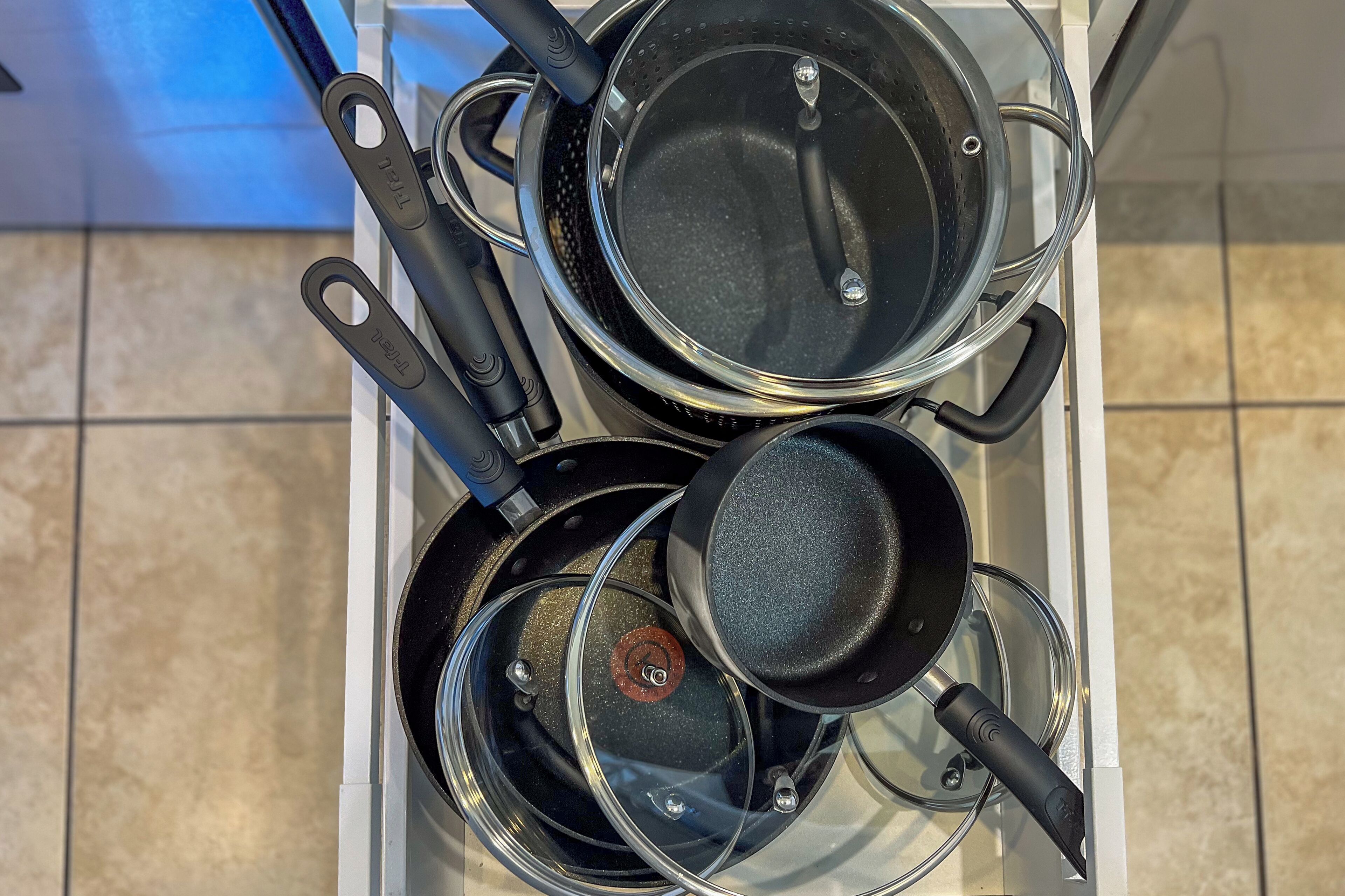 A kitchen with a stove, pots, and pans.