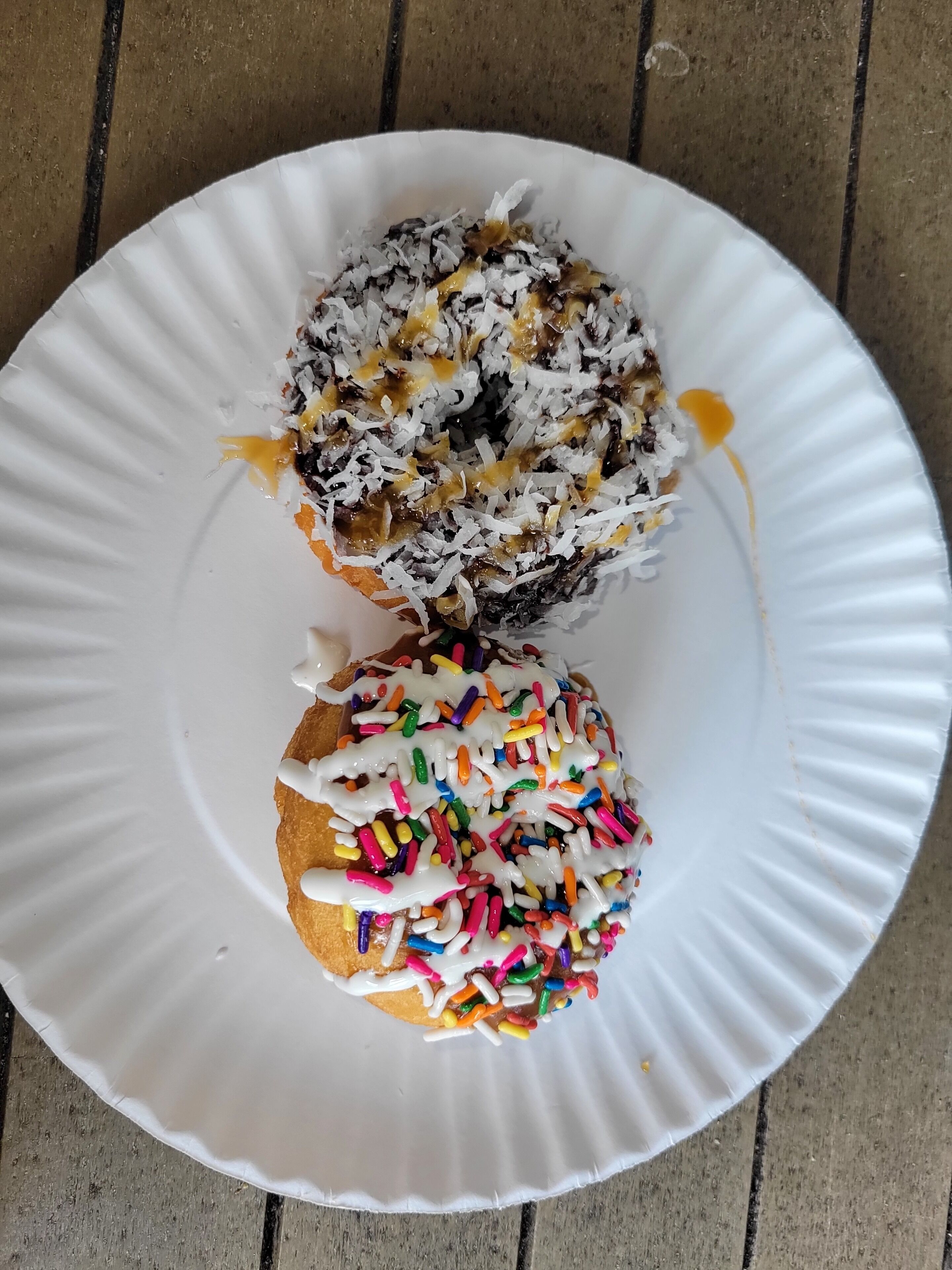 Two donuts on a white paper plate.