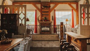 A spacious room with a wooden ceiling, a long table, and a view of the outdoors. - Island View Cottage: Waterfront-BBQ-Sauna-AC-Wifi, Island View Cottage (Flatlands)