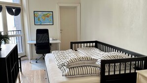 A bedroom with a bed, desk, chair, and a map on the wall. - Classical 3 bedroom, 2 bath, minutes walk from Royal Palace, Shopping & Downtown (Oslo)