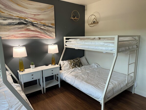 A bunk bed room with a desk, two lamps, and a painting on the wall. - Epic Family Retreat, Hot Tub, Fire Pit, Near Legoland (Vista)