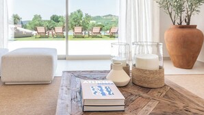 A cozy reading nook with a book, candles, and a view of a garden and pool. - Villa Selena Antequera by Ruralidays (Málaga)