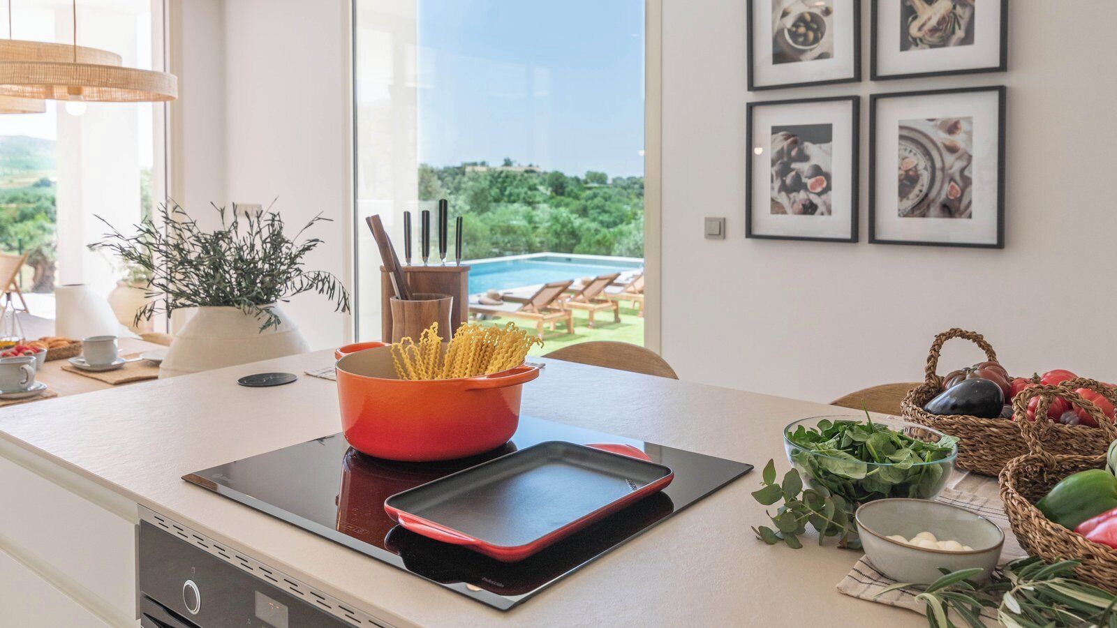 A modern kitchen with a view of a pool, a tablet on the counter, and various kitchen items.