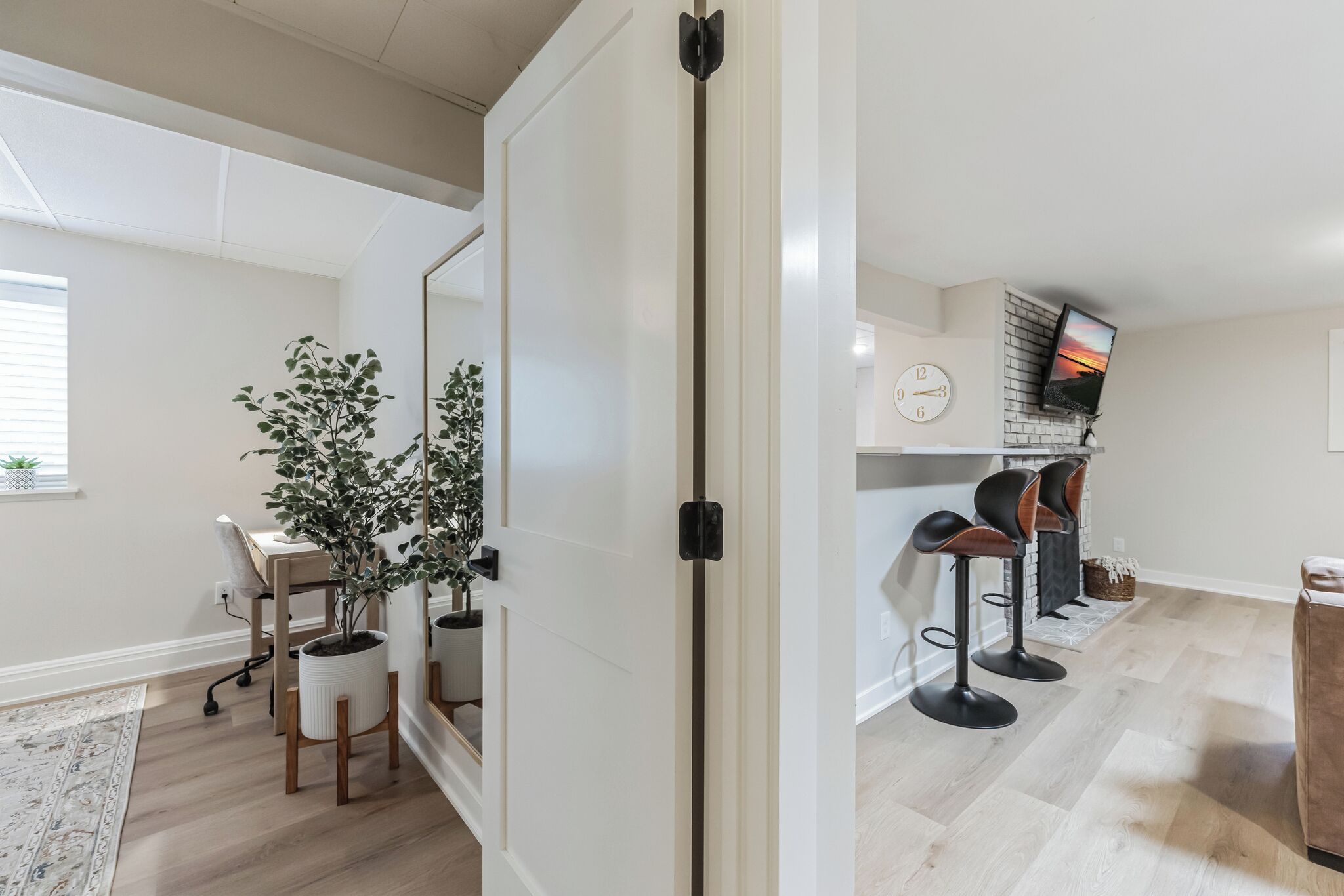 Een moderne keuken met een tegelwand, een eethoek met een tafel en stoelen, en een aan de muur bevestigde televisie.