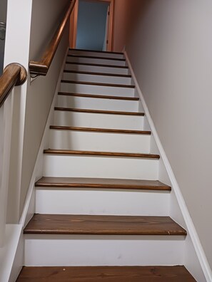 A staircase with wooden steps and a wooden handrail.