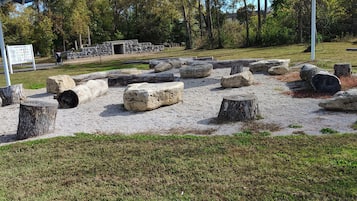 A park with stone structures, grassy areas, and trees.