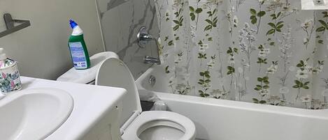 A bathroom with a toilet, sink, and bathtub.