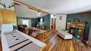 A cozy living room with a fireplace, wooden flooring, and a television. - “Paradise Hill”  A Charming 3-bedroom house in the country. (Victor)