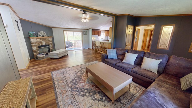 A spacious living room with a wooden floor, a brown leather sofa, a wooden coffee table, and a fireplace. - “Paradise Hill”  A Charming 3-bedroom house in the country. (Victor)