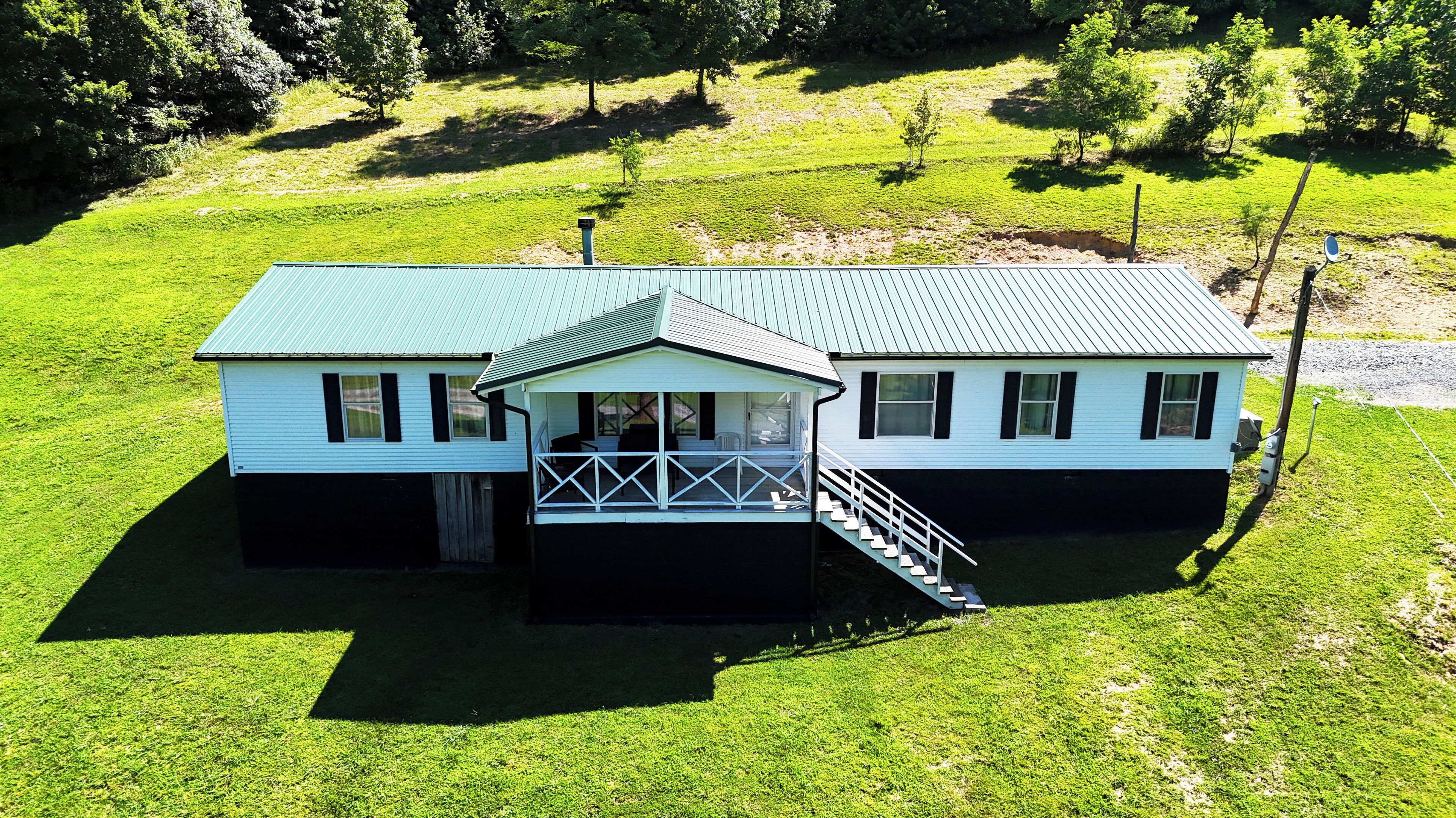 A two-story house with a covered porch and a staircase leading to the upper level.