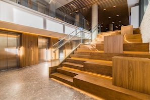 A modern interior with a staircase, wooden flooring, and a glass railing. - Go 24 By My Way (Porto Alegre)