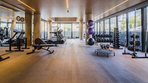 A gym with cardio equipment, weightlifting stations, and large windows. - Go 24 By My Way (Porto Alegre)