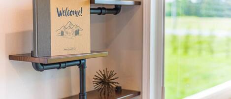 Eine Wandablage mit einem 'Welcome!'-Schild und einem 'Visitor Guest Book' an einer Metallrohrkonstruktion.