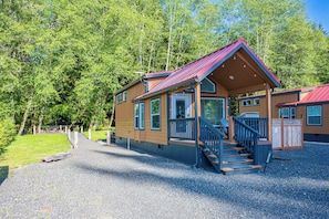 A cabin with a porch, steps, and a gravel driveway. - Rainforest Tiny Home Retreat: Farmhouse (Forks)