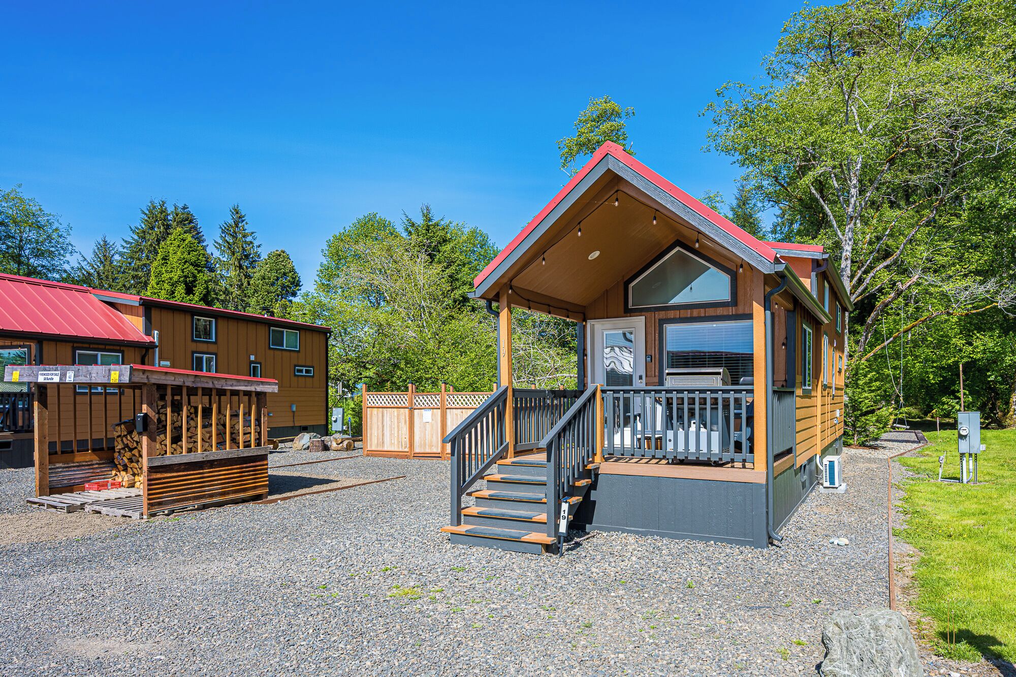 A cabin with a porch, wooden deck, and a staircase leading to the entrance.