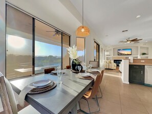 Enjoy meals with a view of the water and a bridge from this dining area, featuring a large table for two and a fully equipped kitchen.