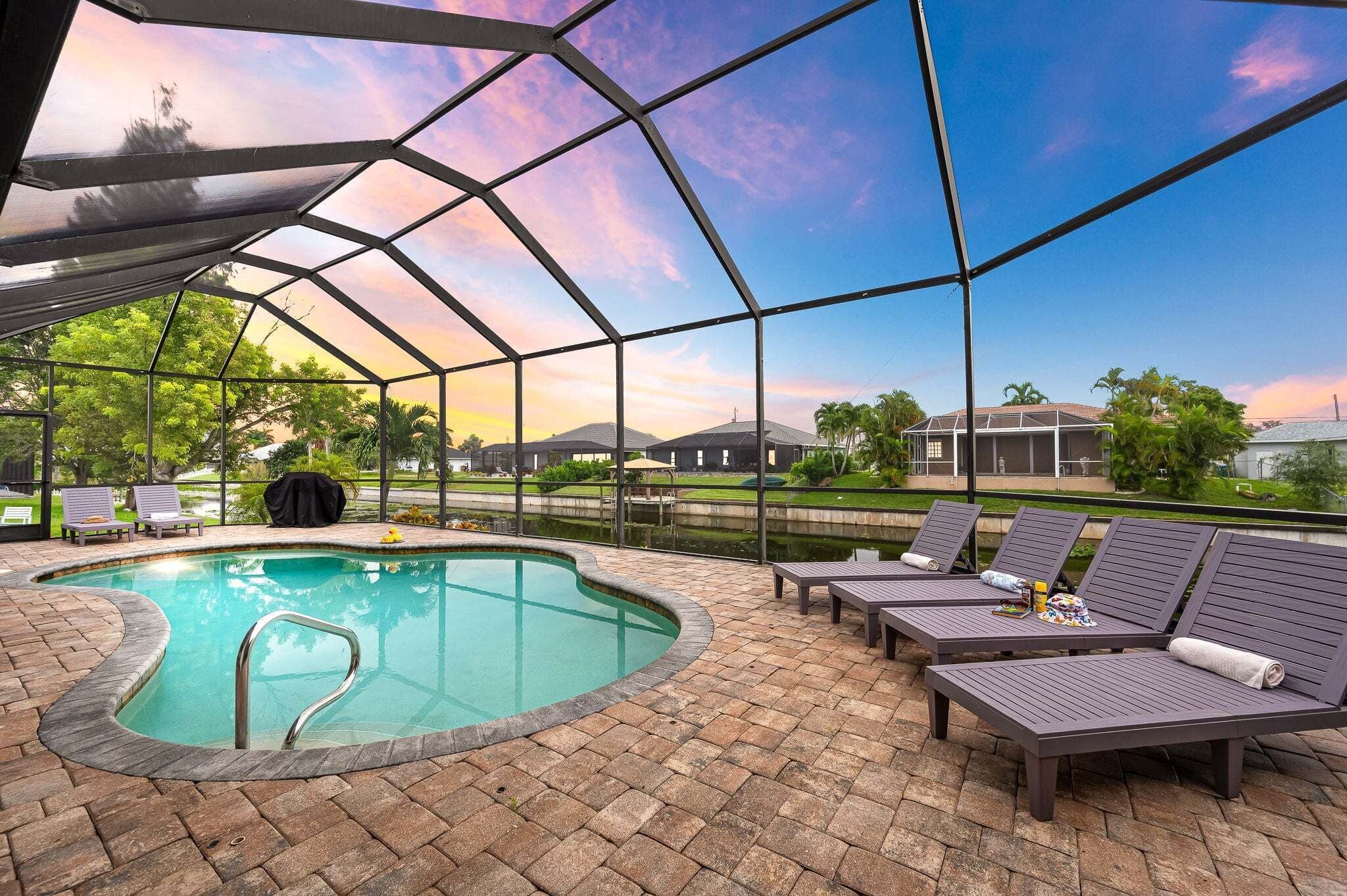 A pool area with lounge chairs and a covered patio.