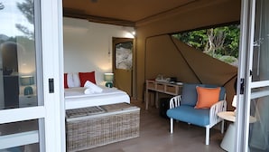 A tented accommodation with a bed, a table, and a chair. - Queen tent 10 Nelly bay (Nelly Bay)