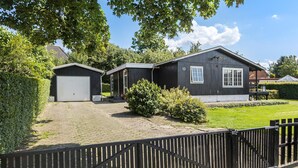 Un bâtiment à deux étages, doté d’un garage et d’un porche abrité.
