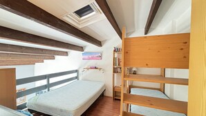 A dormitory room with bunk beds, a skylight, a bookshelf, and a painting on the wall. - STUDIO MEZZANINE POUR 4 PERSONNES CLIMATISE (LE CAP D AGDE)