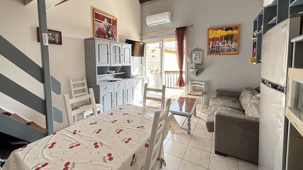 A compact living space with a dining area, kitchenette, and seating area. - STUDIO MEZZANINE POUR 4 PERSONNES CLIMATISE (LE CAP D AGDE)