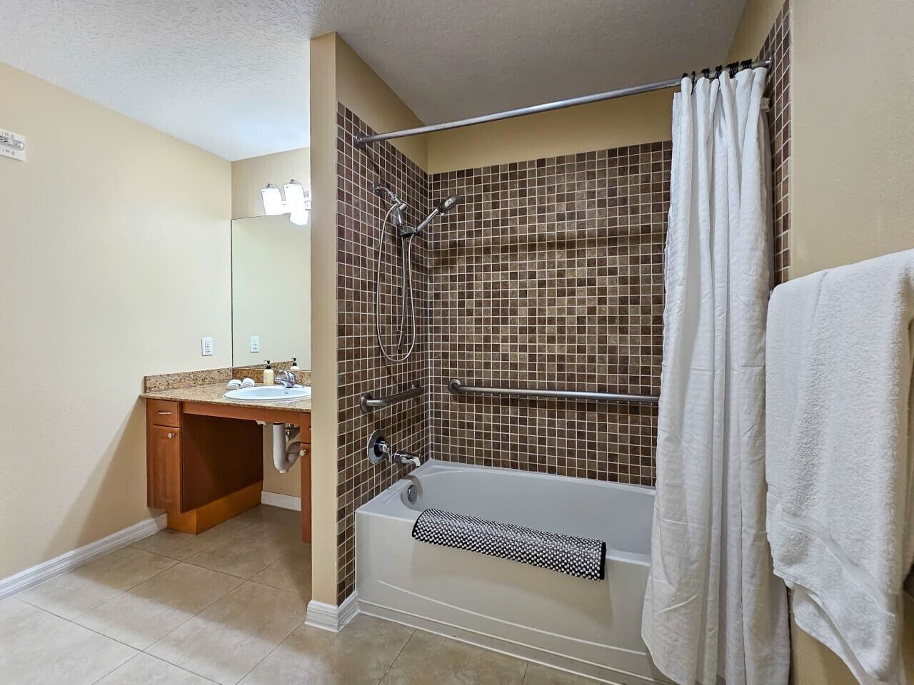 Ein Badezimmer mit Dusche, Badewanne, Waschbecken und Spiegel.