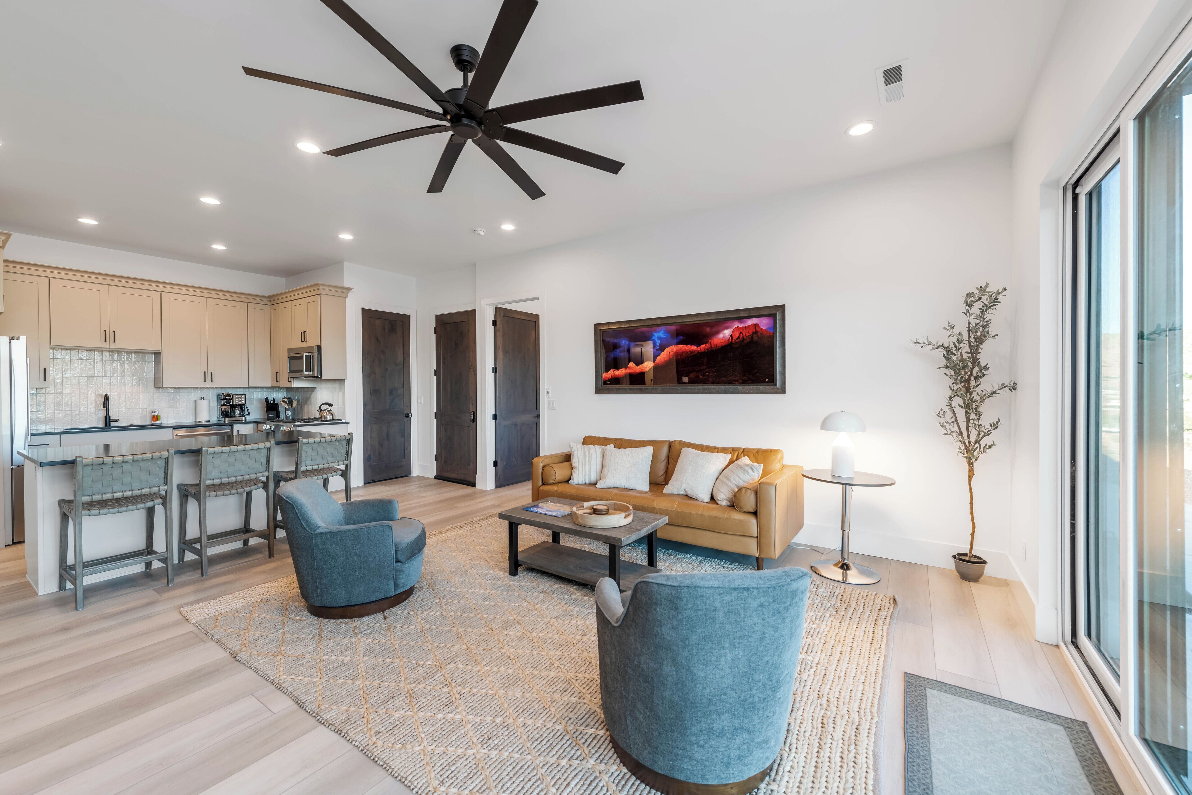 A modern living room with a sofa, chairs, a coffee table, and a TV.