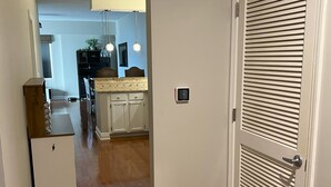 A hallway with wooden flooring leading to a kitchen area with a dining table and chairs. - BEST view of Louisville (Jeffersonville)