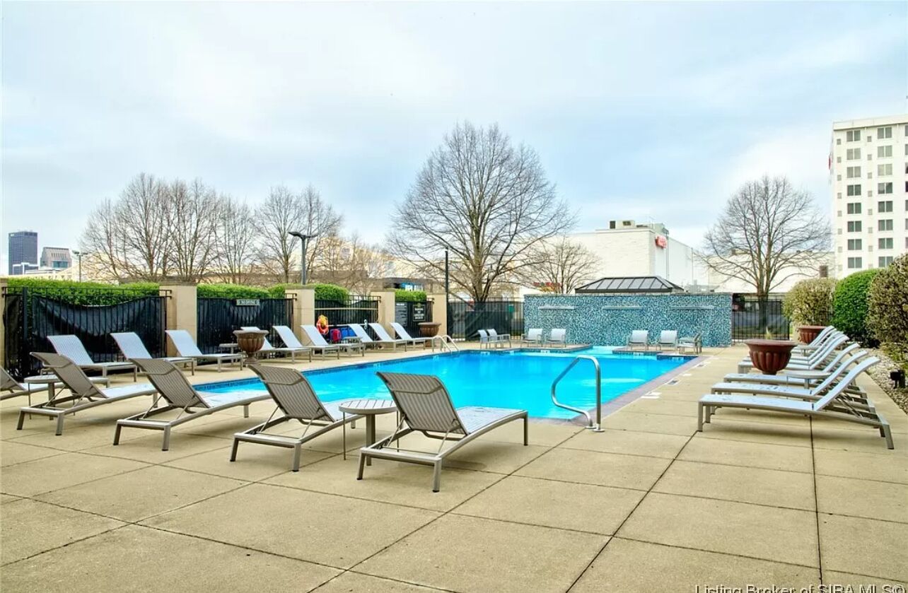 Ein Poolbereich auf dem Dach mit Liegestühlen und einem klaren, blauen Pool.