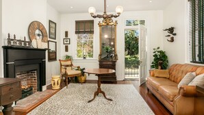 A cozy living room with a fireplace, a wooden coffee table, a leather sofa, and a large mirror.