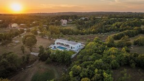 An aerial view of a modern house with a swimming pool, surrounded by dense greenery and a clear sky. - Villa Benina Rossa Inn (Istria - Žminj) (Žminj)