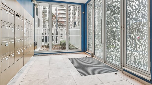 Een modern interieur met lockers, een glazen deur naar buiten en een ruitverdeling van geglazuurd glas.
