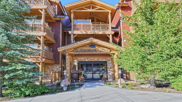 A lodge with a wooden facade, multiple balconies, and a sign reading 'Black Bear Lodge.' - World-class Ski spot + Year-round Pool & Hot Tub! (Park City)