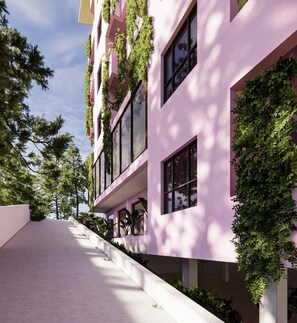 A modern building with a pink facade, large windows, and vertical gardens. - Nature Hotel (Xuan Huong - Da Lat)