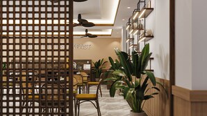 Un interior moderno con comedor, mostrador de recepción y un letrero que dice "BREAKFAST".