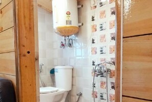A bathroom with a toilet, a water heater, and a shower. - Eden Hotel & Resort Shimla (Shimla)