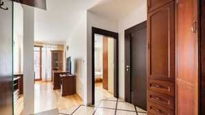 Een hotelkamer met een houten garderobe, een bed, een televisie en uitzicht op buiten.