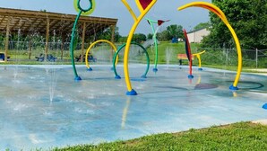 Un espace de jeux aquatiques doté de nombreuses fontaines et de structures colorées.