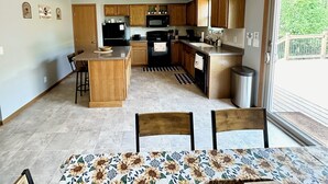 Une cuisine de taille réduite, dotée de meubles en bois, d’un îlot central et d’un ventilateur de plafond.