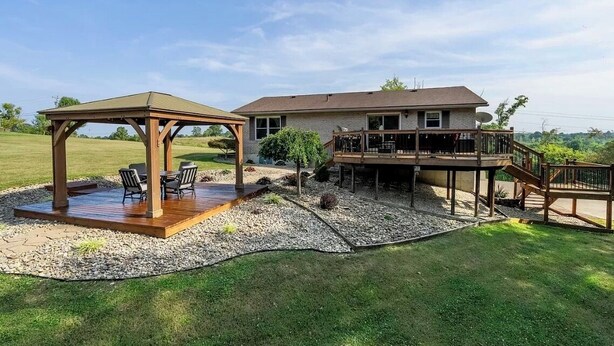Une maison dotée d’un patio couvert, d’une terrasse et d’une antenne parabolique.